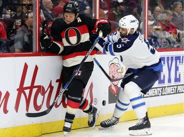 Chris Neil of the Ottawa Senators is hit by Mark Stuart of the Winnipeg Jets during first period NHL action.