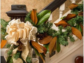 The banister in Maureen Patterson's 1910 Victorian is decorated with gold bows, greenery and magnolia leaves.