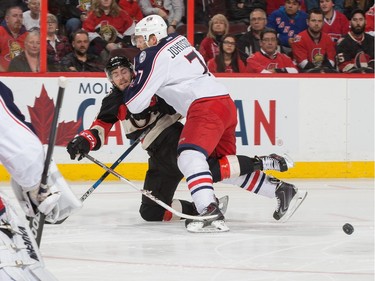 Jack Johnson #7 of the Columbus Blue Jackets checks Mike Hoffman #68 of the Ottawa Senators to the ice.