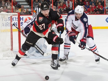 Curtis Lazar #27 of the Ottawa Senators battles for puck possession against Kevin Connauton #4 of the Columbus Blue Jackets.