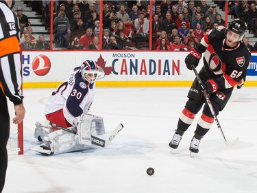 Curtis McElhinney #30 of the Columbus Blue Jackets makes a save on a penalty shot by Mike Hoffman #68 of the Ottawa Senators.