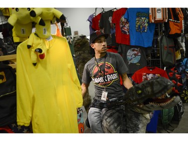 Cosplayer rides a dinosaur as he browses for merchandise at Pop Expo