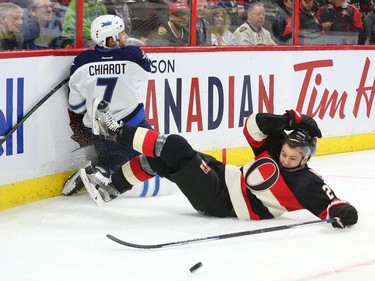 Curtis Lazar of the Ottawa Senators collides with Ben Chiarot of the Winnipeg Jets during first period NHL action.