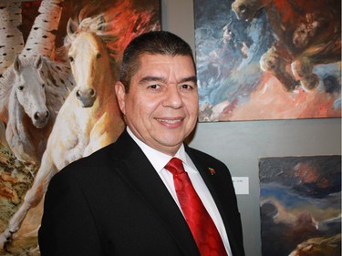 Embassy of Venezuela took part in the Latin American Art Exhibition Nov. 4 at Saint Brigid's Centre for the Arts. Ambassador Wilmer Omar Barrientos Fernandez stands in front of art by Venezuelan Amneris Fernandez.