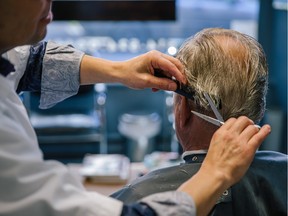 MONTREAL, QUE.: SEPTEMBER 24, 2015 -- Chilean-born barber Manuel Baeza gives a haircut to client Jacques Viret at his barbershop Barbier Manuel Baeza in the borough of Plateau-Mont-Royal in Montreal on Thursday, September 24, 2015.