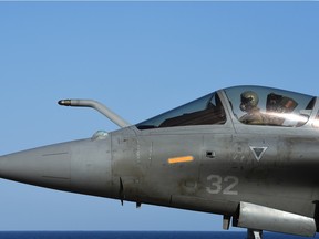 A French navy pilot prepares a French Rafale fighter aircraft before his bombing run against the Islamic State (ISIL). Canada plans to stop its own bombing mission and replace that with expanded training.