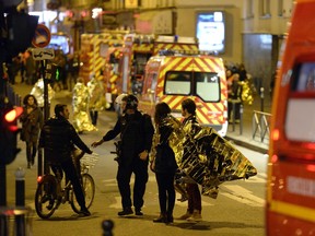 People are being evacuated on rue Oberkampf near the Bataclan concert hall in central Paris, early on November 14, 2015. At least 120 people were killed in a series of terror attacks in Paris on November 13 according to a provisional total, a source close to the investigation said.