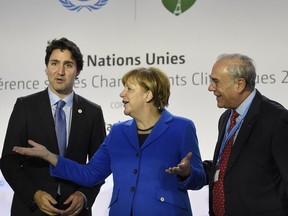 (From L) Prime Minister Justin Trudeau, German Chancellor Angela Merkel and OECD president Angel Gurria attend a Heads of State media event on carbon pricing, as part of the COP21 United Nations conference on climate change in Le Bourget on the outskirts of the French capital Paris on November 30, 2015.