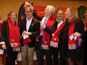 From left, Melanie Joly, minister of Canadian heritage, Ottawa Mayor Jim Watson, Don Needham, chair of experience Canada, Guy Laflamme, executive director of the Ottawa 2017 Bureau and Deborah Morrison, executive director of Experiences Canada have some fun with some toques and scarves during a press conference at the Lord Elgin hotel Friday November 27, 2015.