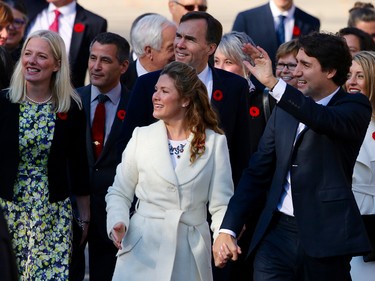 Justin Trudeau (r) waves while walking up the drive to Rideau Hall along with his wife Sophie (c), Ottawa Centre MP Catherina McKenna (l)  and the rest of the Liberal cabinet to be sworn in.