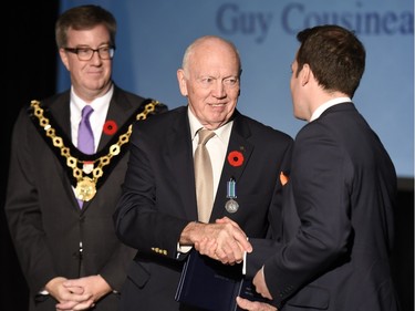 Guy Cousineau receives the Order of Ottawa from Mayor Jim Watson and Councillor Mathieu Fleury at City Hall in Ottawa on Tuesday, November 10, 2015.