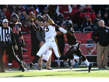 Hamilton Tiger-Cats wide receiver Kealoha Pilares, left, makes a catch in front of Ottawa Redblacks defensive back Jovon Johnson during first half action in the CFL East Division final in Ottawa, Sunday November 22, 2015.