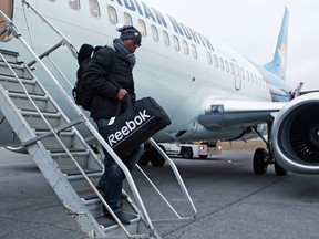 Henry Burris of the Ottawa Redblacks walks off the plane in Ottawa on Monday, Nov. 30, 2015 after returning from a loss to Edmonton in the Grey Cup game at Winnipeg.