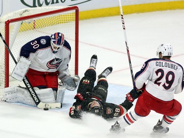 Ottawa Senators' Mike Hoffman (68) is tripped by Columbus Blue Jackets' Cody Goloubef (29) as Blue Jackets goalie Curtis McElhinney (30) makes the save during first period NHL hockey action in Ottawa Thursday, November 19, 2015.