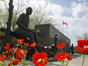 Poppies surround the newly unveiled statue of Lt.-Col. John McCrae to commemorate the Second Battle of Ypres and his poem 'In Flanders Fields,' during a ceremony in Ottawa on Sunday, May 3, 2015.
