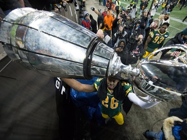 Edmonton Eskimos' John Ojo hoists the Grey Cup trophy up to fans after defeating the Ottawa Redblacks to win the 103rd Grey Cup in Winnipeg, Man. Sunday, Nov. 29, 2015.