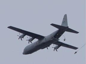 In this file photo, Canadian paratroopers jump from a C-130J aircraft.