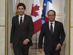 Canadian Prime Minister Justin Trudeau and French President Francois Hollande  enter the room at the Palce Elysee to deliver joint statements, in Paris, France, on Sunday, Nov. 29, 2015. Trudeau is in Paris to attend the United Nations climate change summit.