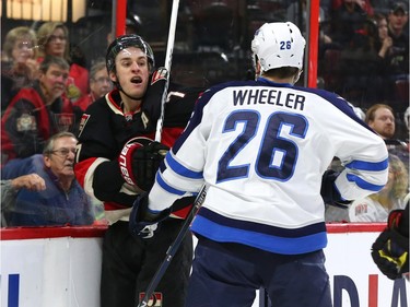 Kyle Turris of the Ottawa Senators scraps with Blake Wheeler of the Winnipeg Jets during first period NHL action.