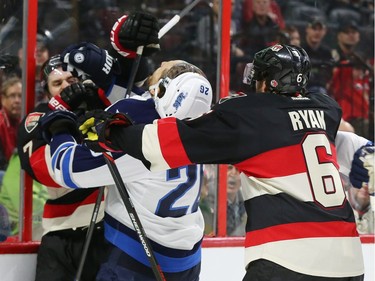 Kyle Turris, left, of the Ottawa Senators scraps with Blake Wheeler of the Winnipeg Jets during first period NHL action.