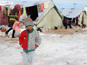 A Syrian child stands in the snow in a refugee camp in the town of Arsal in the Lebanese Bekaa valley in this file photo.