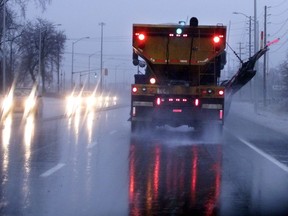 Truck applies salt during winter storm.