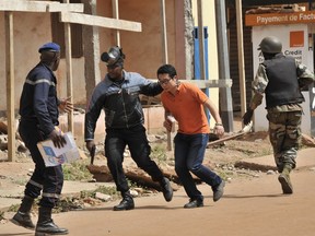 Malian security forces evacuate a man from an area surrounding the Radisson Blu hotel in Bamako on November 20, 2015. Gunmen went on a shooting rampage at the luxury hotel in Mali's capital Bamako, seizing 170 guests and staff in an ongoing hostage-taking that has left at least three people dead.