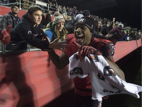 Ottawa Redblacks wide receiver Maurice Price celebrates with fans after the Redblacks beat the Hamilton Tiger-Cats on Nov. 7, 2015 to clinch top spot in the East.
