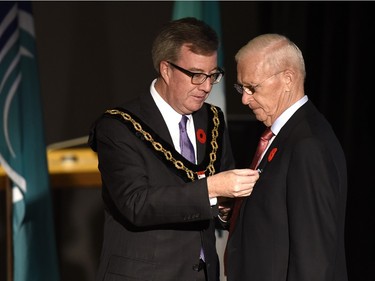Mayor Jim Watson pins the Order of Ottawa medal on Ottawa Senators General Manager Bryan Murray.