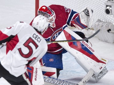 Montreal Canadiens goalie Mike Condon gloves a shot off Ottawa Senators' Cody Ceci for the save during first period NHL action.