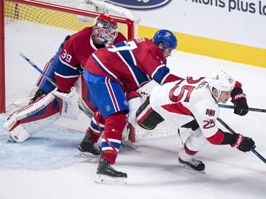 Ottawa Senators' Chris Neil is taken out from in front of Montreal Canadiens goalie Mike Condon by defenseman Tom Gilbert during first period NHL action.