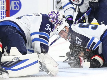 Milan Michalek of the Ottawa Senators crushed to the ice by Tyler Myers of the Winnipeg Jets during first period NHL action.