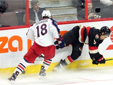 Ottawa Senators' Cody Ceci (5) is checked by Columbus Blue Jackets' Rene Bourque (18) during first period NHL hockey action in Ottawa Thursday, November 19, 2015.