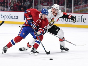 Paul Byron #41 of the Montreal Canadiens controls the puck against Mark Borowiecki #74  of the Ottawa Senators.