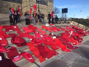 Persons from First Nations and supporters gather on Parliament Hill on November 3, 2015, many carrying red dresses representing murdered and missing aboriginal women, to remind all that the problem needs to be resolved.