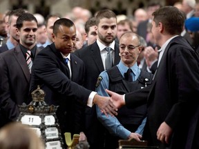 House of Commons Speaker Andrew Scheer, right, shakes hands with Const. Samearn Son on Thursday as other security members look on in the House of Commons as they are honoured for their efforts during the Oct. 22, 2014, shooting on Parliament Hill. Son, who was shot in the leg when a gunman stormed Parliament Hill, says he thought he would die that day.