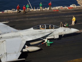 Flight deck personnel perform prelaunch checks on an F/A-18F Super Hornet in this file photo from the U.S. Navy.