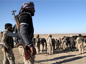 Fighters from the Syrian Democratic Forces (SDF) coalition, which includes Kurds, Arabs and Syriac Christians, gather on the outskirts of the northeastern town of Al-Hol, in the Syrian Hasakeh province on November 14, 2015 after they took control of the area from fighters from the Islamic State group.  The SDF coalition said it delivered a blow to IS logistics, announcing that it had driven the jihadists out of Al-Hol, an important village on their Iraq-Syria supply route.