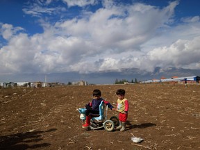 Syrian refugee boys play at a refugee camp in the town of Hosh Hareem, in the Bekaa valley, east Lebanon, Wednesday, Oct. 28, 2015. The United Nations said the worsening conflict in Syria has left 13.5 million people in need of aid and some form of protection, including more than six million children.