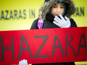 The Afghan-Canadian Community of Ottawa held a vigil Saturday Nov. 28, 2015 on Parliament Hill to denounce the beheading of Hazaras in Zabul, Afghanistan. Hasina Habibullah held a sign on the steps during the vigil.