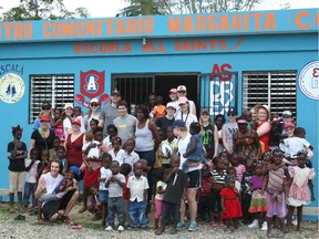 In the most recent Dominican trip, Mark Podgorski (in back with the blue ball cap), All Saints students and Dominican students pose outside a school built with funds raised by the Ottawa high school.