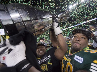 Tony Washington (58) and others members of the Edmonton Eskimos hoist the Grey Cup after they defeated Ottawa Redblacks at the 103rd Grey Cup in Winnipeg, Man. Sunday, Nov. 29, 2015.