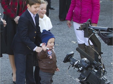 Prime Minister-designate Justin Trudeau's children Xavier, Ella-Grace and Hadrien (right to left) wave to a television camera as they wait for their parents to arrive at Rideau Hall in Ottawa, November 4, 2015.