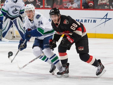 Mike Hoffman #68 of the Ottawa Senators and battles for a loose puck against Adam Cracknell #24 of the Vancouver Canucks.