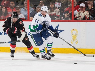 Matt Bartkowski #44 of the Vancouver Canucks skates with the puck as Milan Michalek #9 of the Ottawa Senators chases him down.
