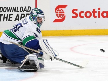 Ryan Miller #30 of the Vancouver Canucks makes a stick save against the Ottawa Senators.