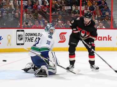 Ryan Miller #30 of the Vancouver Canucks watches the puck go wide as Milan Michalek #9 of the Ottawa Senators looks for the rebound.