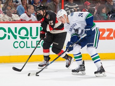 Zack Smith #15 of the Ottawa Senators covers his mouth after receiving a high stick by Adam Cracknell #24 of the Vancouver Canucks.