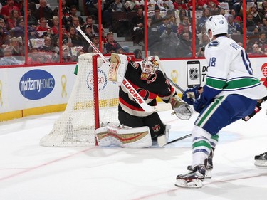 Andrew Hammond #30 of the Ottawa Senators makes a blocker save against Jake Virtanen #18 of the Vancouver Canucks.