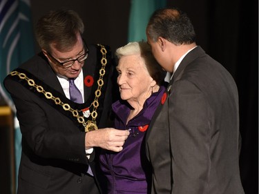 Vera Mitchell receives the Order of Ottawa from Mayor Jim Watson and Councillor George Darouze at City Hall in Ottawa on Tuesday, November 10, 2015.